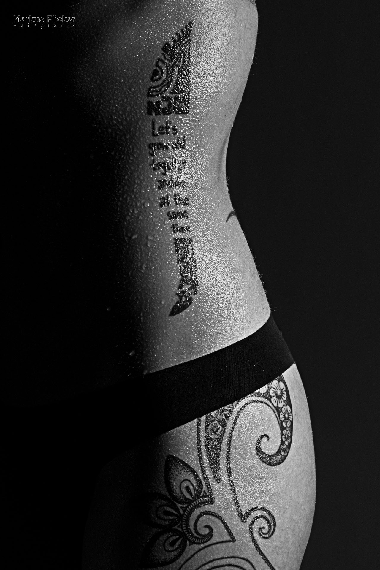 Low Key Wassertropfen auf der Haut und Tattoos Dessous Photography