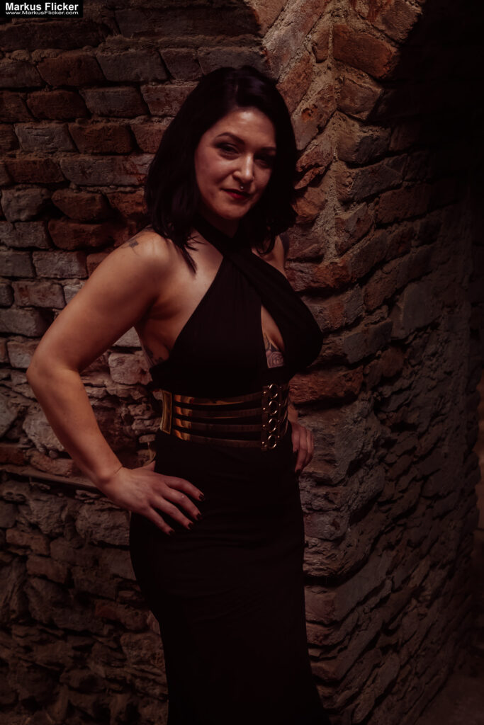 Verborgene Eleganz: Ein Fotoshooting mit Female Model Elisa im historischen Keller von Graz. Frau Elisa im Scheinwerferlicht des Grazer Gewölbes. Eleganz in der Dunkelheit: Modefotografie mit Elisa in Graz inkl. 37 Fototipps zum Fotografieren im Keller