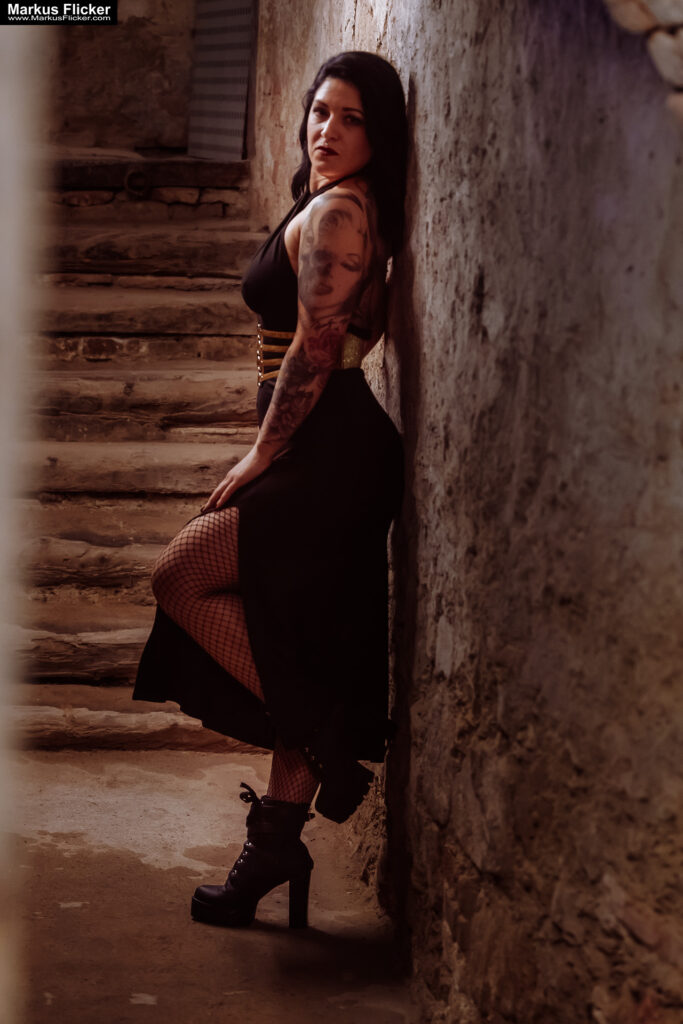 Verborgene Eleganz: Ein Fotoshooting mit Female Model Elisa im historischen Keller von Graz. Frau Elisa im Scheinwerferlicht des Grazer Gewölbes. Eleganz in der Dunkelheit: Modefotografie mit Elisa in Graz inkl. 37 Fototipps zum Fotografieren im Keller