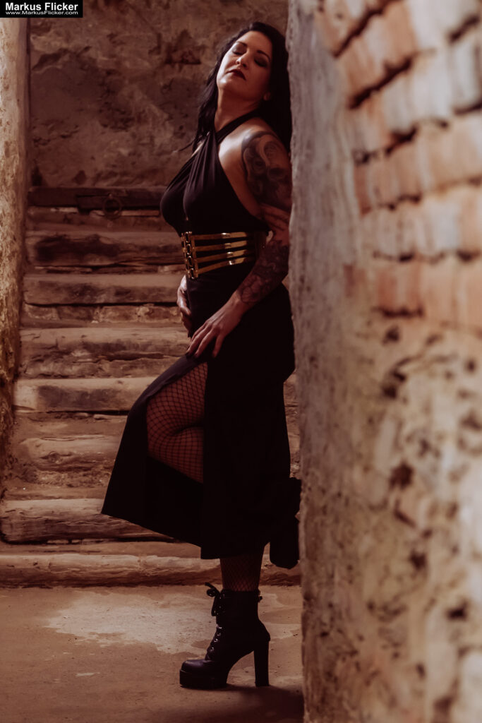 Verborgene Eleganz: Ein Fotoshooting mit Female Model Elisa im historischen Keller von Graz. Frau Elisa im Scheinwerferlicht des Grazer Gewölbes. Eleganz in der Dunkelheit: Modefotografie mit Elisa in Graz inkl. 37 Fototipps zum Fotografieren im Keller
