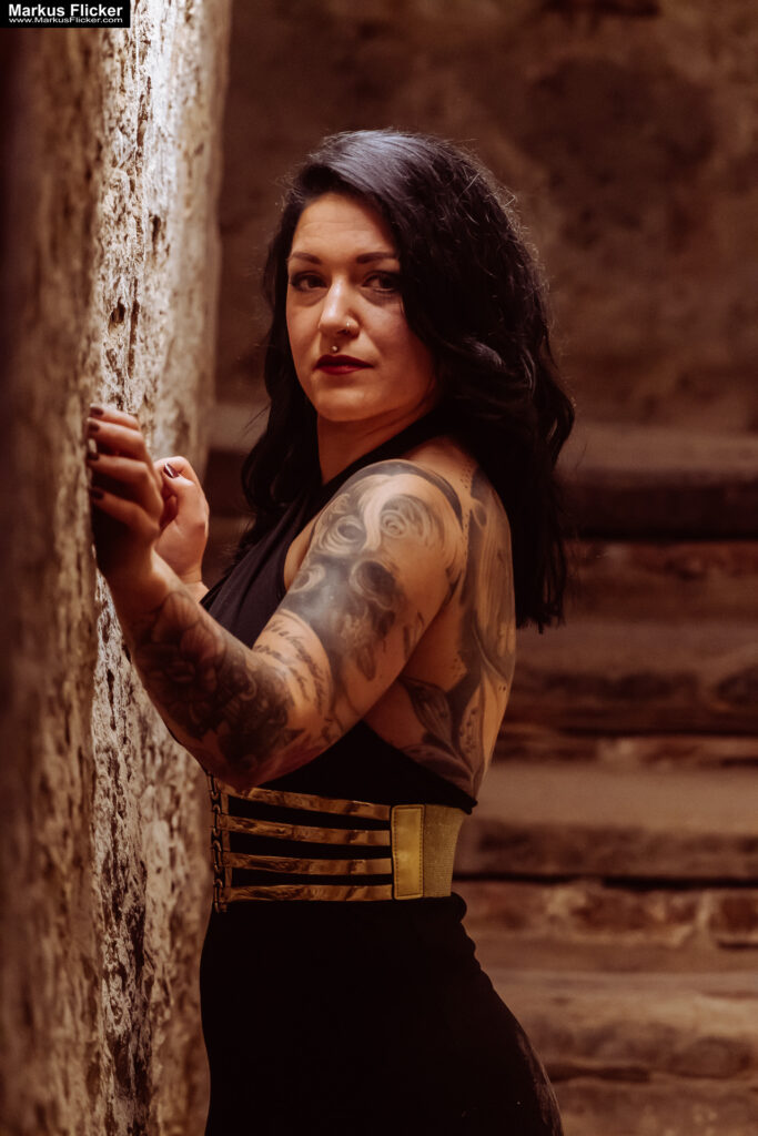 Verborgene Eleganz: Ein Fotoshooting mit Female Model Elisa im historischen Keller von Graz. Frau Elisa im Scheinwerferlicht des Grazer Gewölbes. Eleganz in der Dunkelheit: Modefotografie mit Elisa in Graz inkl. 37 Fototipps zum Fotografieren im Keller