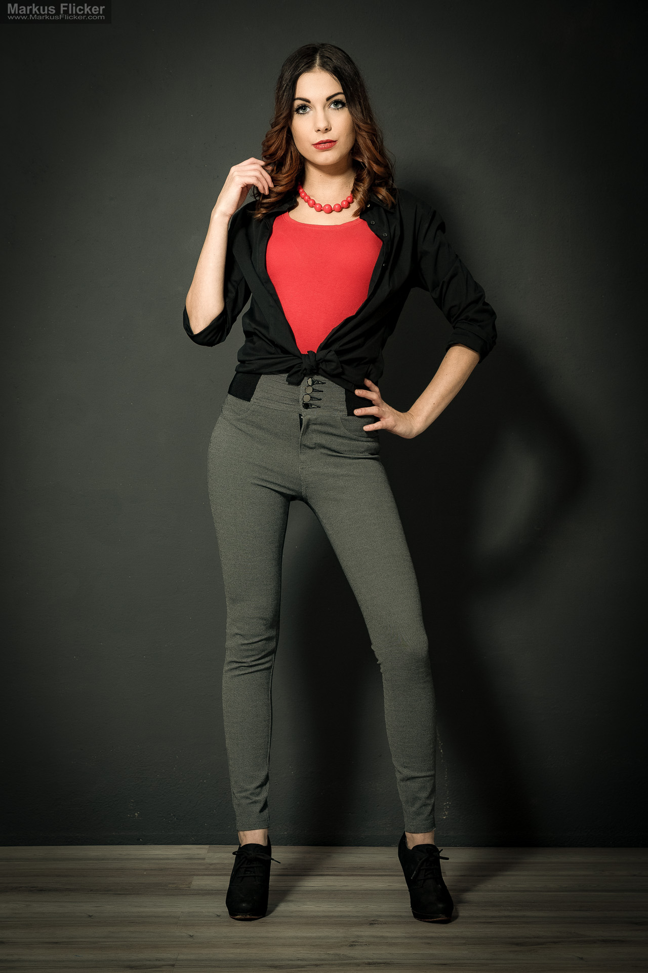 Fashion Portrait Fotografie im Studio – kreatives Model Posing mit rotem Outfit vor dunklem Hintergrund Fashion Portrait Fotografie im Studio – kreatives Model Posing mit rotem Outfit vor dunklem Hintergrund