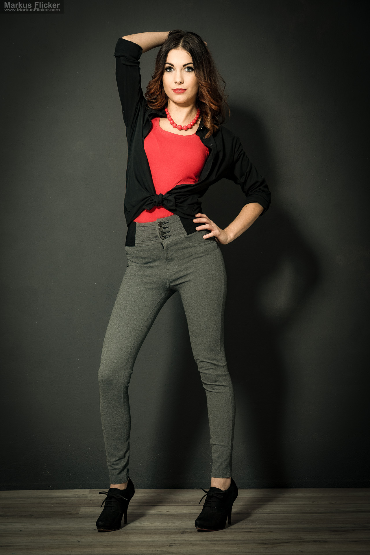 Fashion Portrait Fotografie im Studio – kreatives Model Posing mit rotem Outfit vor dunklem Hintergrund Fashion Portrait Fotografie im Studio – kreatives Model Posing mit rotem Outfit vor dunklem Hintergrund