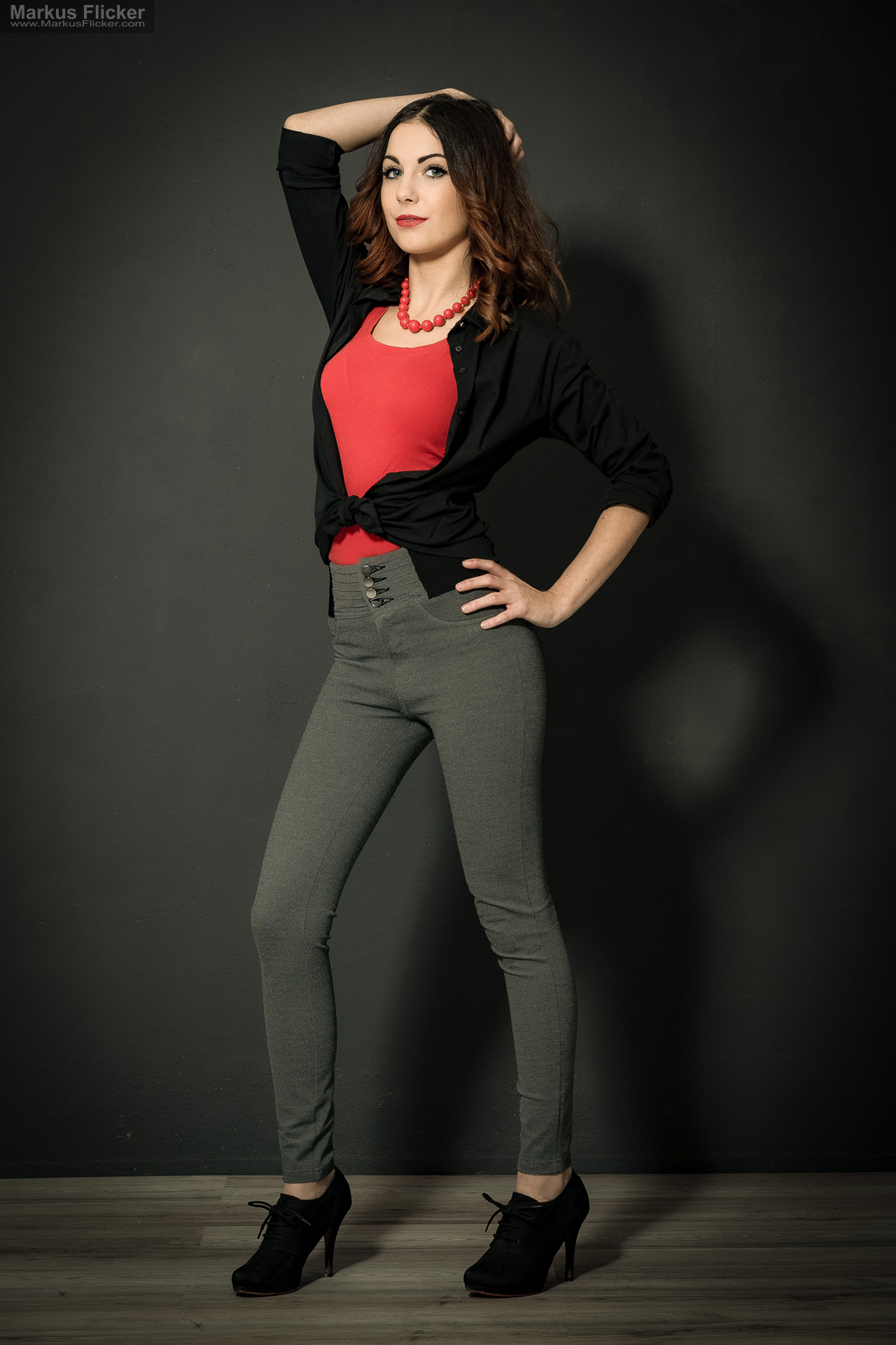Fashion Portrait Fotografie im Studio – kreatives Model Posing mit rotem Outfit vor dunklem Hintergrund Fashion Portrait Fotografie im Studio – kreatives Model Posing mit rotem Outfit vor dunklem Hintergrund