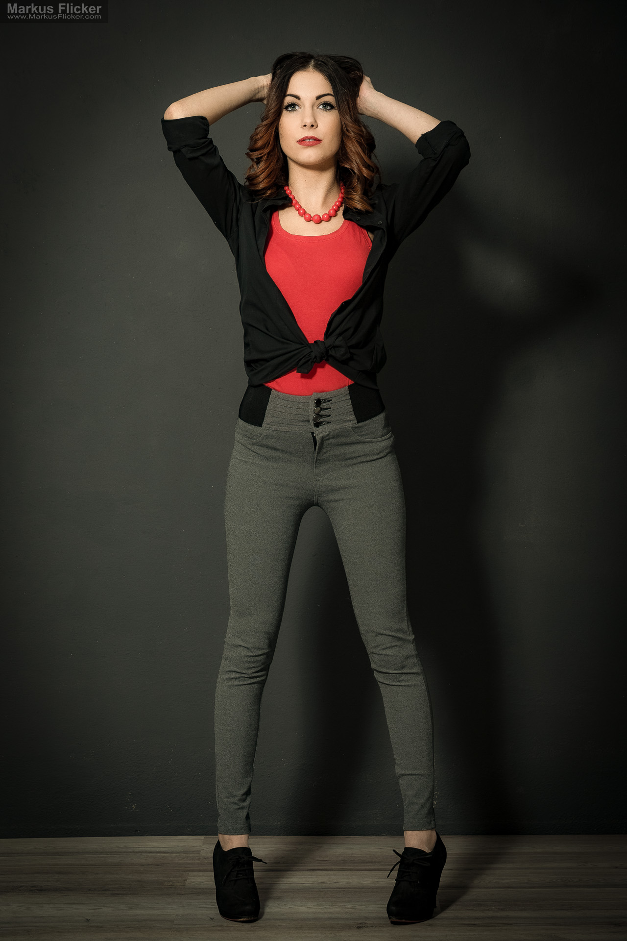Fashion Portrait Fotografie im Studio – kreatives Model Posing mit rotem Outfit vor dunklem Hintergrund Fashion Portrait Fotografie im Studio – kreatives Model Posing mit rotem Outfit vor dunklem Hintergrund