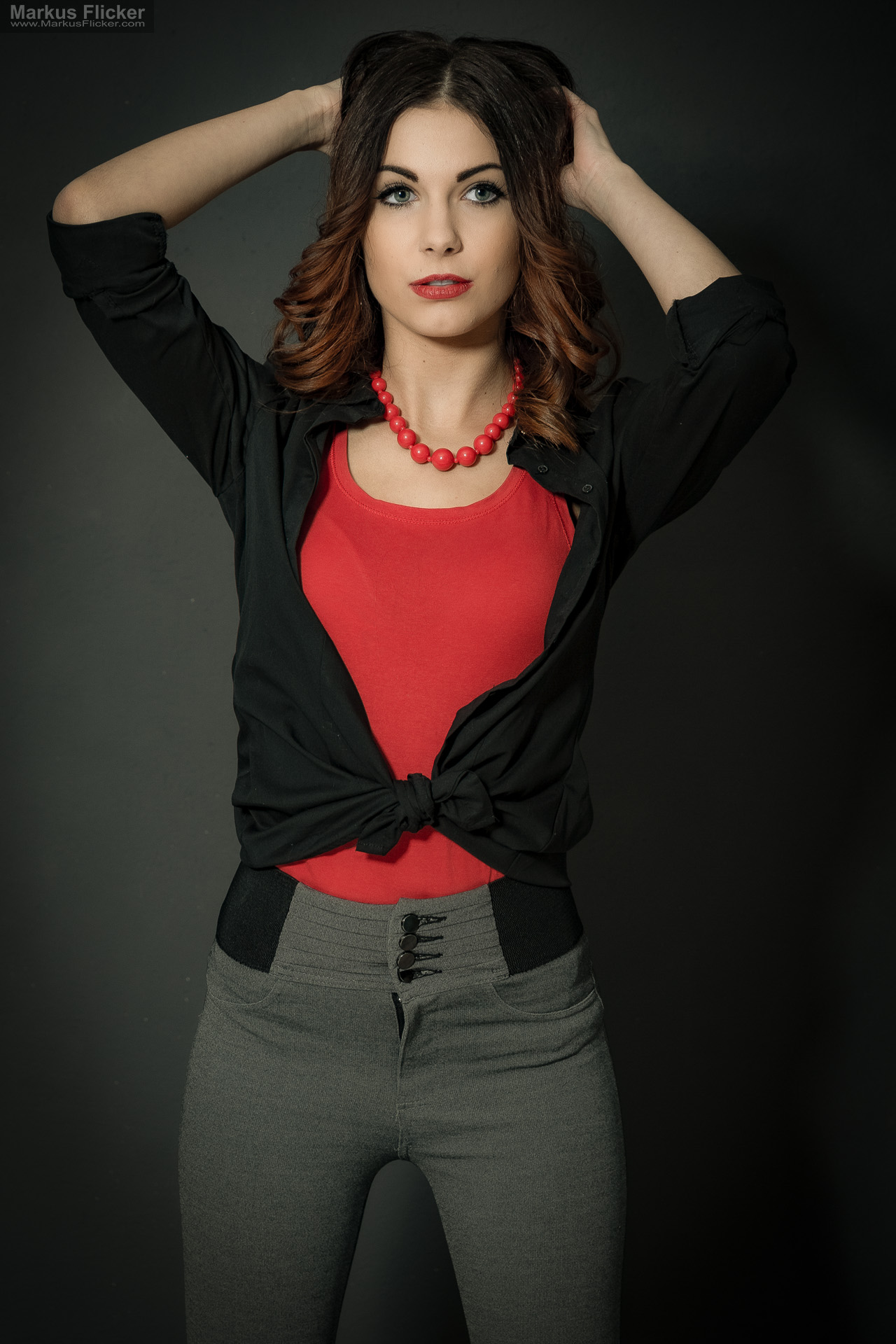 Fashion Portrait Fotografie im Studio – kreatives Model Posing mit rotem Outfit vor dunklem Hintergrund Fashion Portrait Fotografie im Studio – kreatives Model Posing mit rotem Outfit vor dunklem Hintergrund