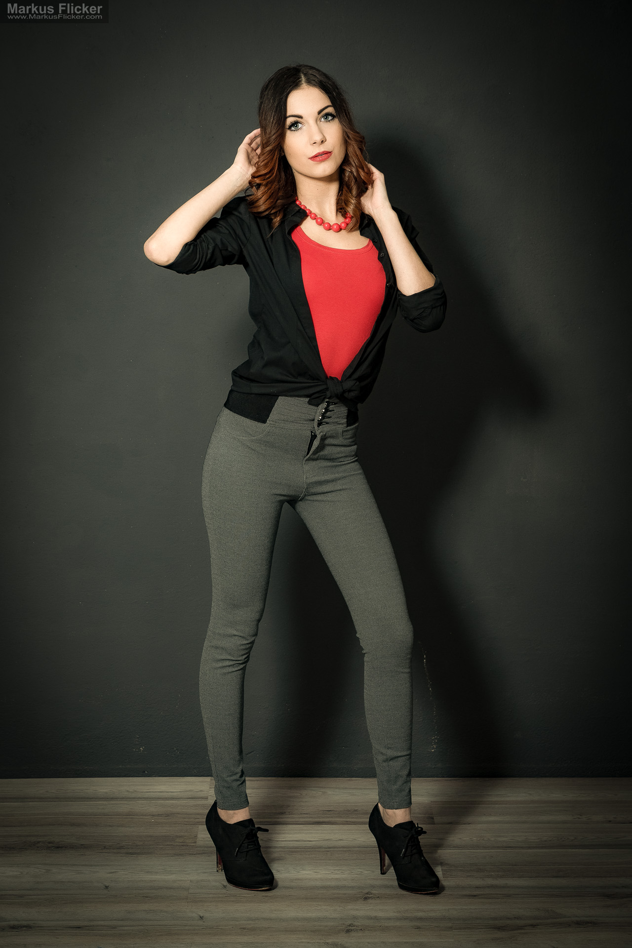 Fashion Portrait Fotografie im Studio – kreatives Model Posing mit rotem Outfit vor dunklem Hintergrund Fashion Portrait Fotografie im Studio – kreatives Model Posing mit rotem Outfit vor dunklem Hintergrund