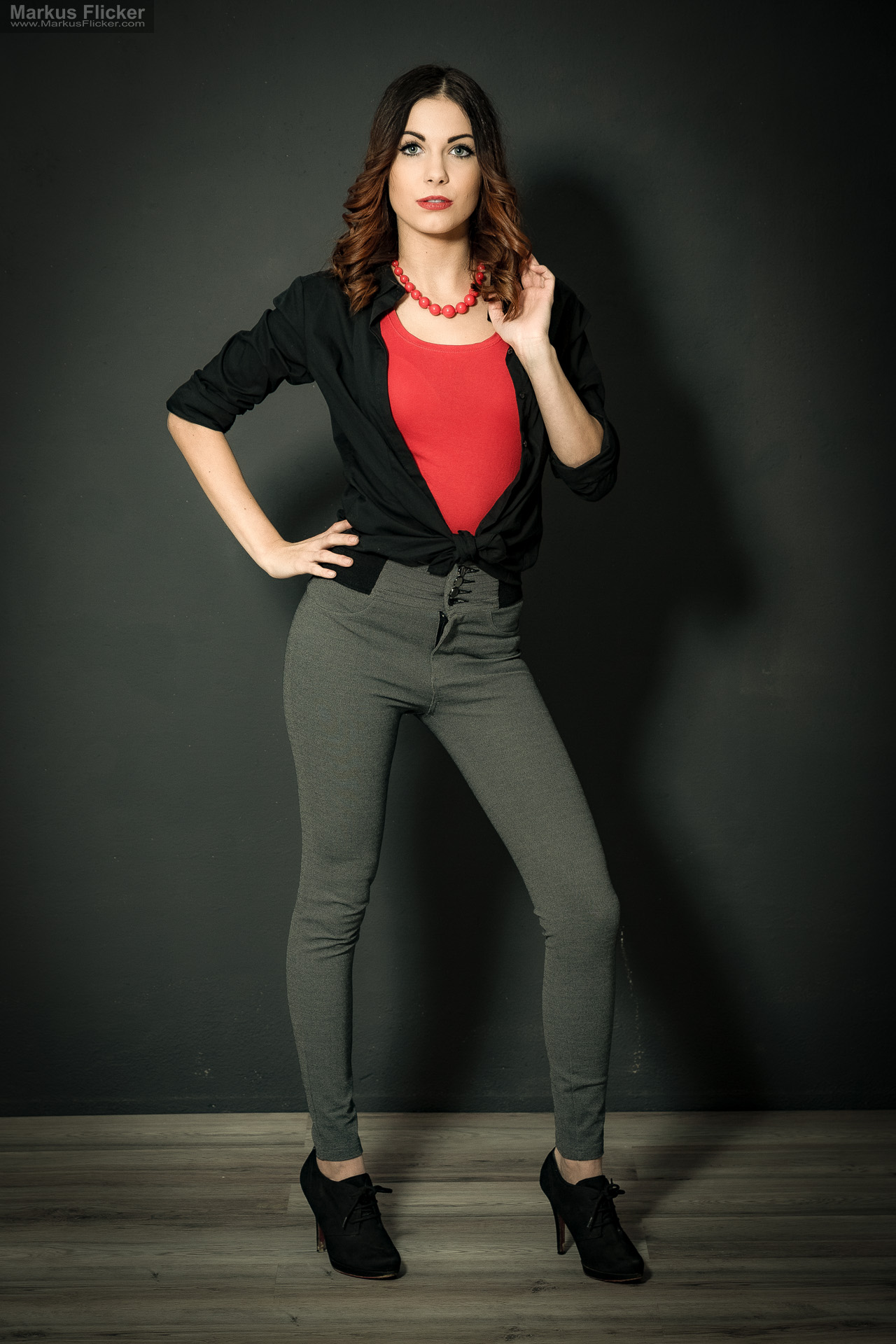 Fashion Portrait Fotografie im Studio – kreatives Model Posing mit rotem Outfit vor dunklem Hintergrund Fashion Portrait Fotografie im Studio – kreatives Model Posing mit rotem Outfit vor dunklem Hintergrund