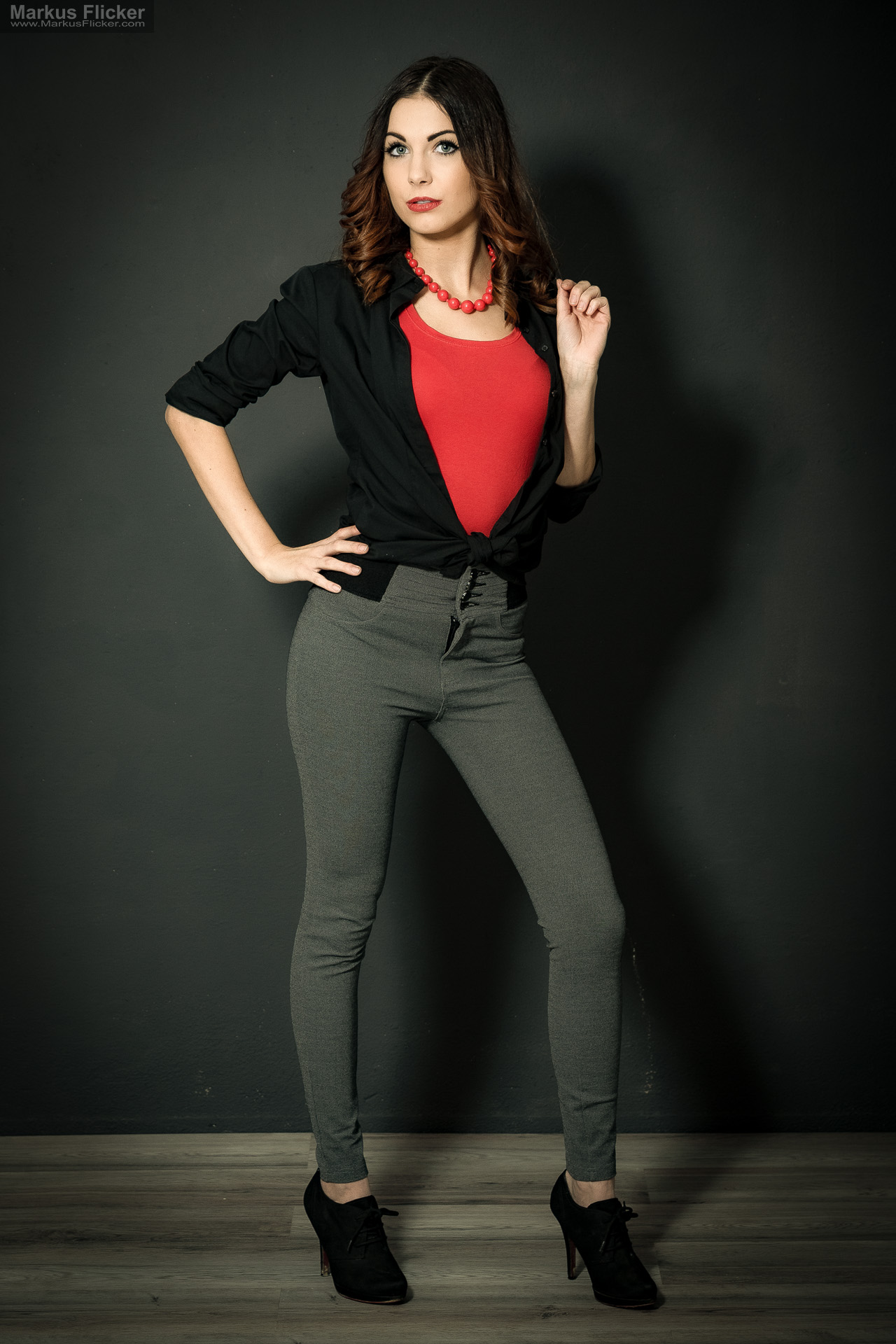 Fashion Portrait Fotografie im Studio – kreatives Model Posing mit rotem Outfit vor dunklem Hintergrund Fashion Portrait Fotografie im Studio – kreatives Model Posing mit rotem Outfit vor dunklem Hintergrund