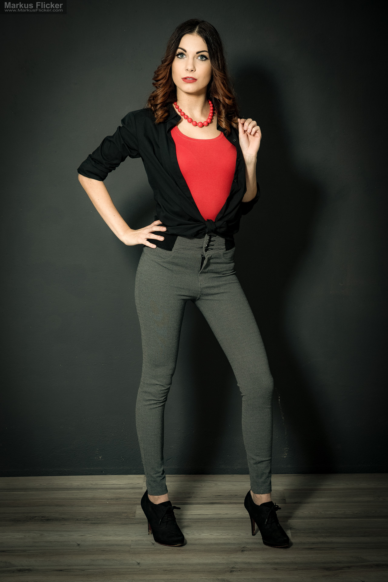 Fashion Portrait Fotografie im Studio – kreatives Model Posing mit rotem Outfit vor dunklem Hintergrund Fashion Portrait Fotografie im Studio – kreatives Model Posing mit rotem Outfit vor dunklem Hintergrund