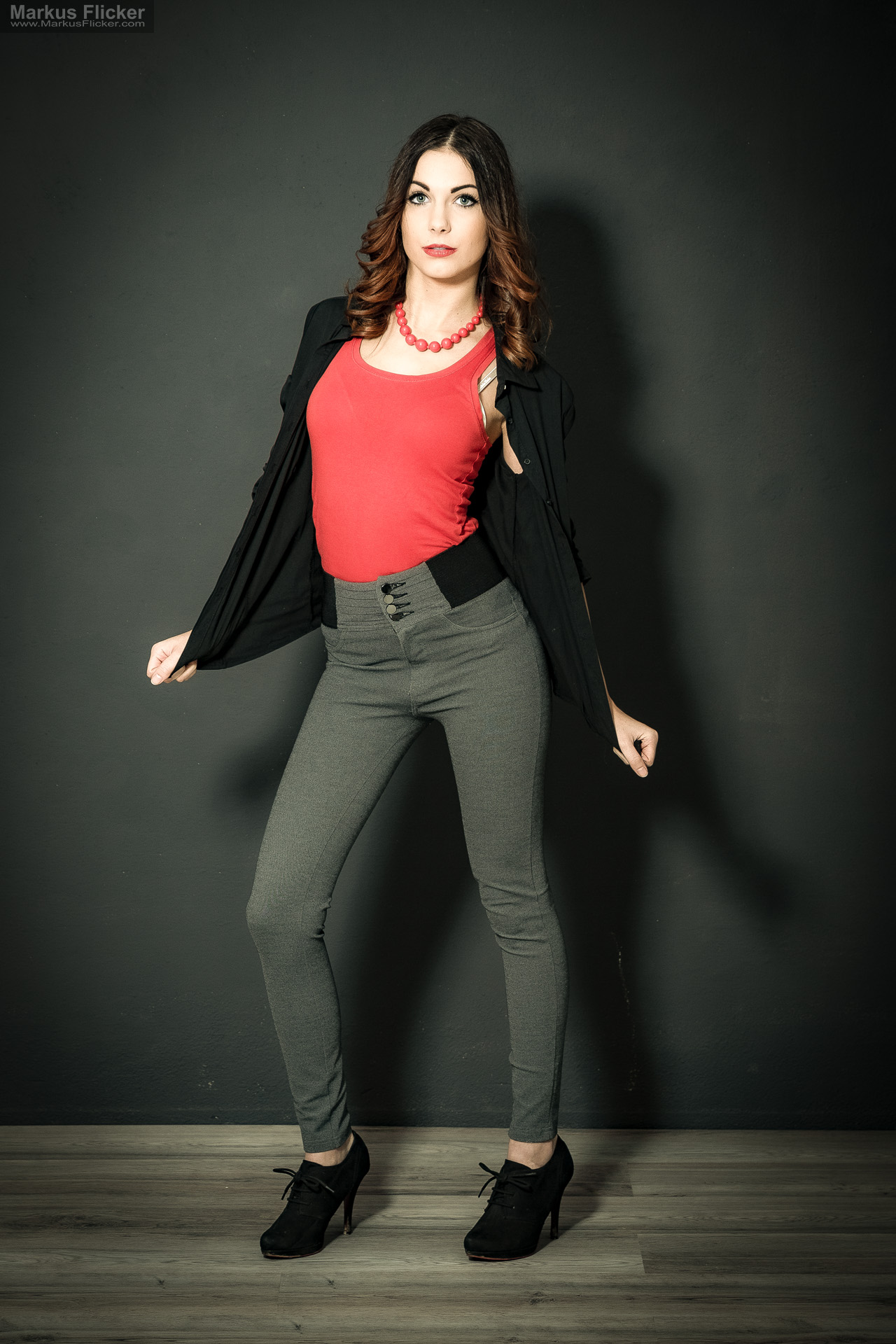 Fashion Portrait Fotografie im Studio – kreatives Model Posing mit rotem Outfit vor dunklem Hintergrund Fashion Portrait Fotografie im Studio – kreatives Model Posing mit rotem Outfit vor dunklem Hintergrund