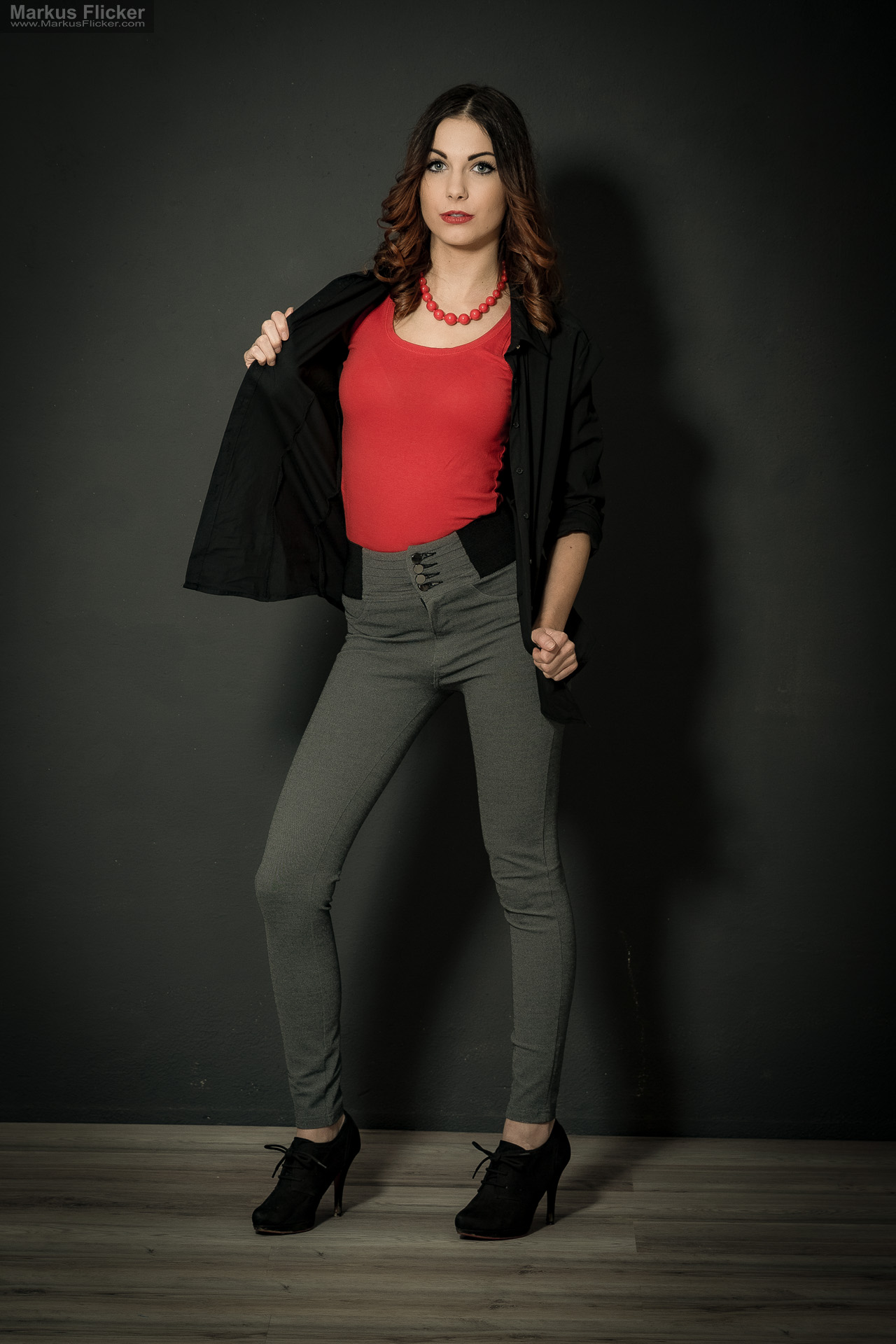 Fashion Portrait Fotografie im Studio – kreatives Model Posing mit rotem Outfit vor dunklem Hintergrund Fashion Portrait Fotografie im Studio – kreatives Model Posing mit rotem Outfit vor dunklem Hintergrund