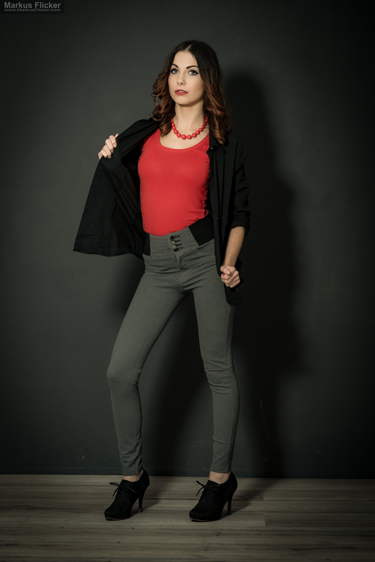 Fashion Portrait Fotografie im Studio – kreatives Model Posing mit rotem Outfit vor dunklem Hintergrund Fashion Portrait Fotografie im Studio – kreatives Model Posing mit rotem Outfit vor dunklem Hintergrund