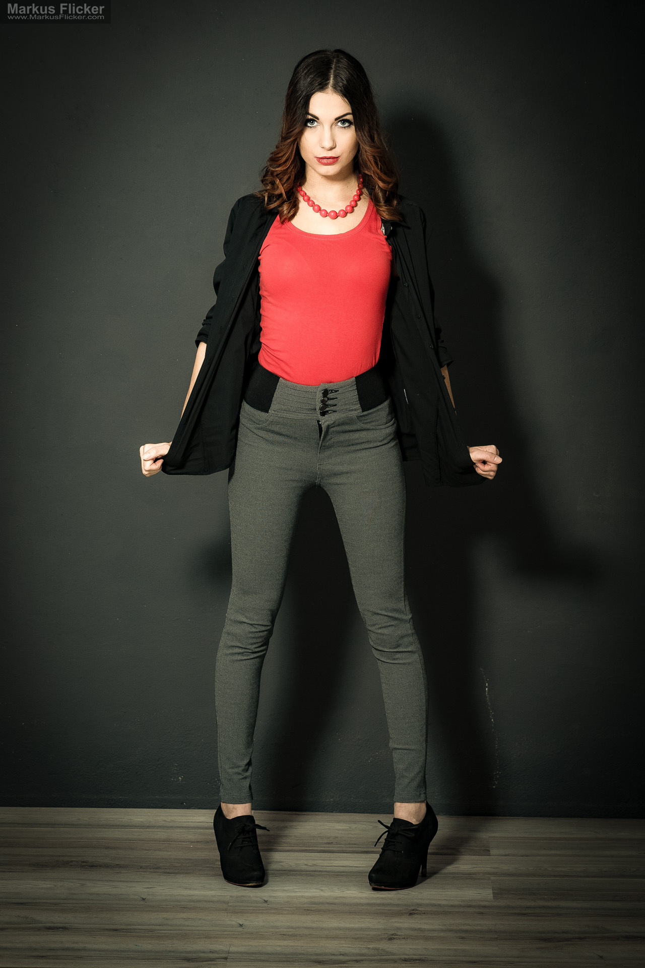 Fashion Portrait Fotografie im Studio – kreatives Model Posing mit rotem Outfit vor dunklem Hintergrund Fashion Portrait Fotografie im Studio – kreatives Model Posing mit rotem Outfit vor dunklem Hintergrund