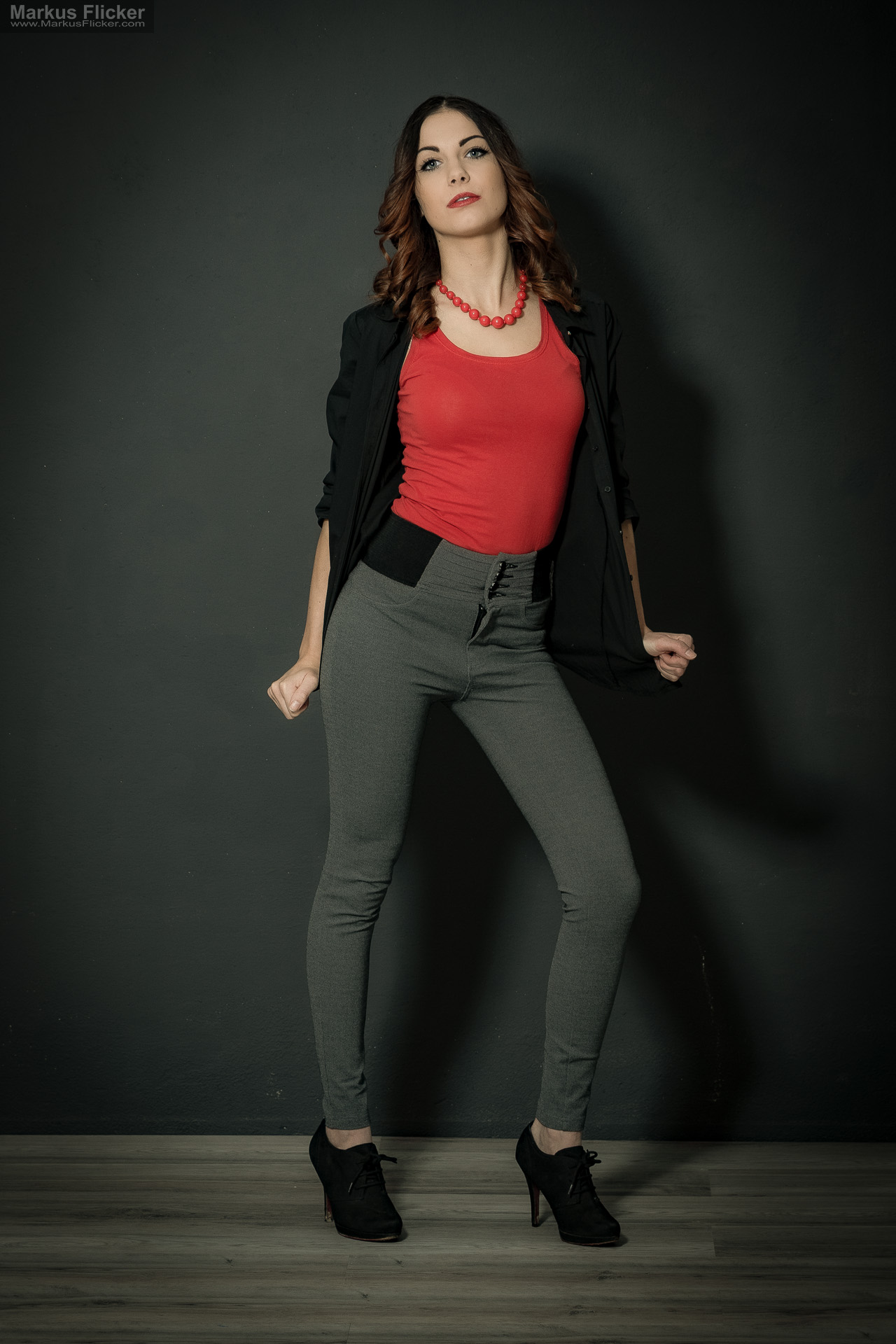 Fashion Portrait Fotografie im Studio – kreatives Model Posing mit rotem Outfit vor dunklem Hintergrund Fashion Portrait Fotografie im Studio – kreatives Model Posing mit rotem Outfit vor dunklem Hintergrund