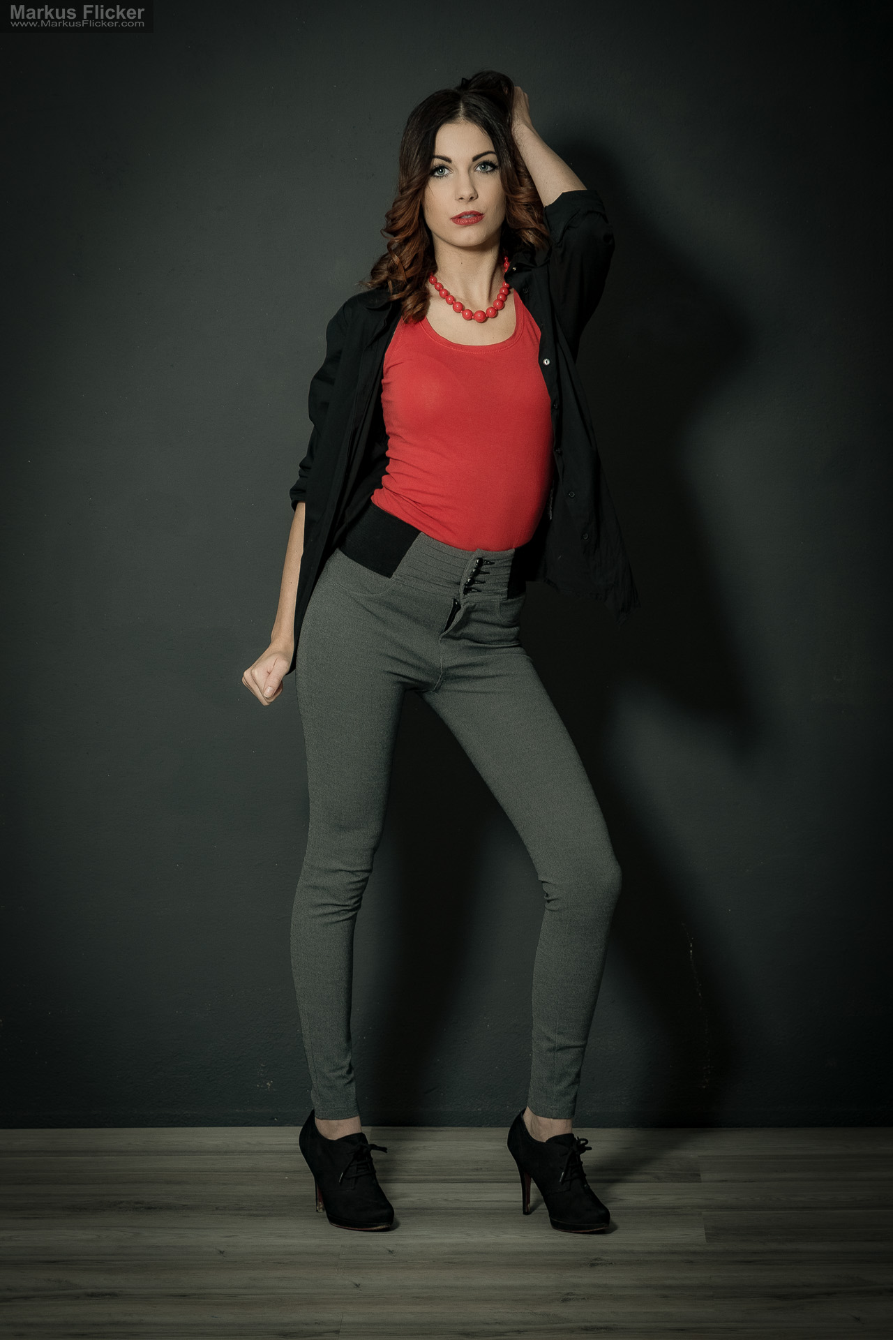 Fashion Portrait Fotografie im Studio – kreatives Model Posing mit rotem Outfit vor dunklem Hintergrund Fashion Portrait Fotografie im Studio – kreatives Model Posing mit rotem Outfit vor dunklem Hintergrund
