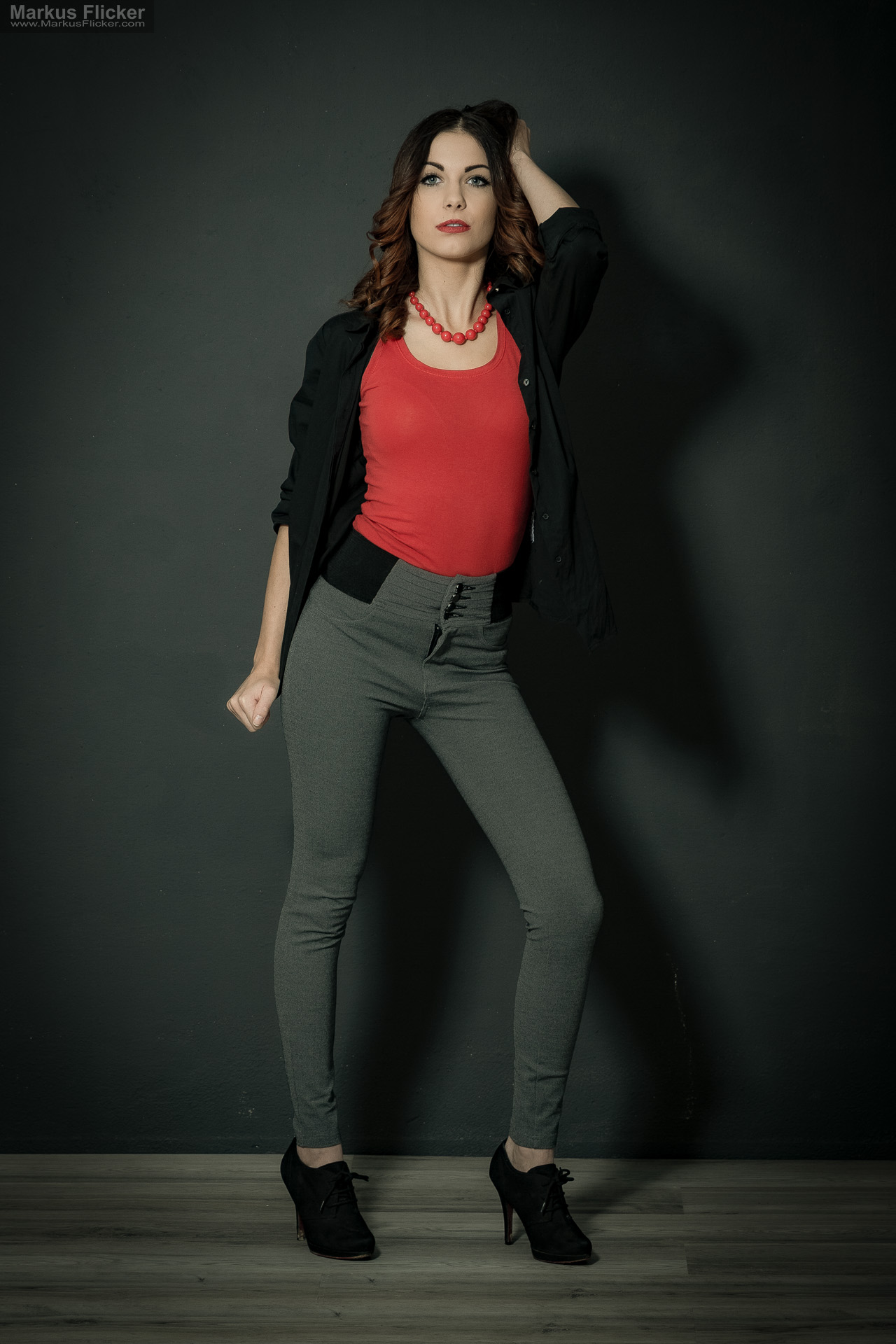 Fashion Portrait Fotografie im Studio – kreatives Model Posing mit rotem Outfit vor dunklem Hintergrund Fashion Portrait Fotografie im Studio – kreatives Model Posing mit rotem Outfit vor dunklem Hintergrund