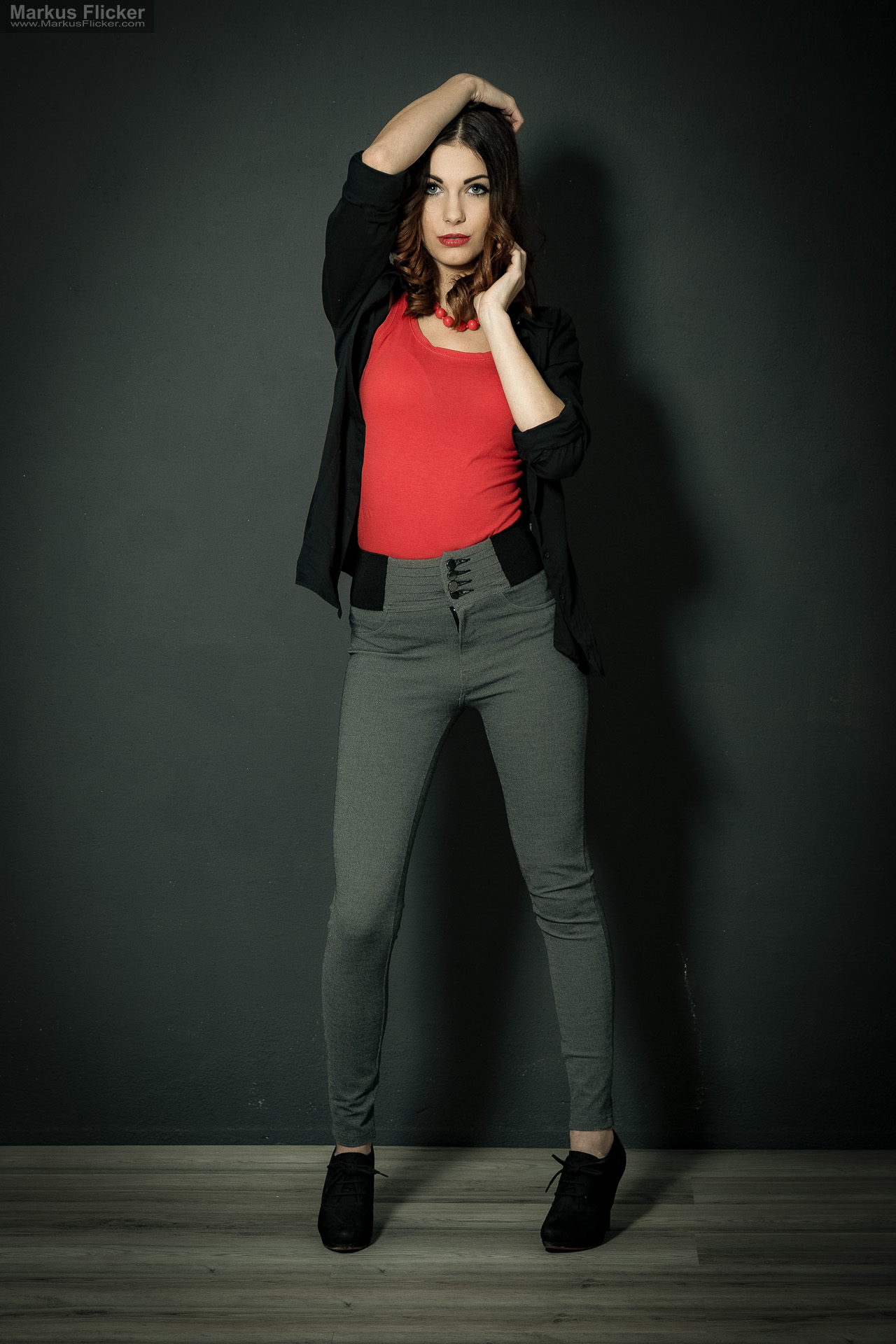 Fashion Portrait Fotografie im Studio – kreatives Model Posing mit rotem Outfit vor dunklem Hintergrund Fashion Portrait Fotografie im Studio – kreatives Model Posing mit rotem Outfit vor dunklem Hintergrund