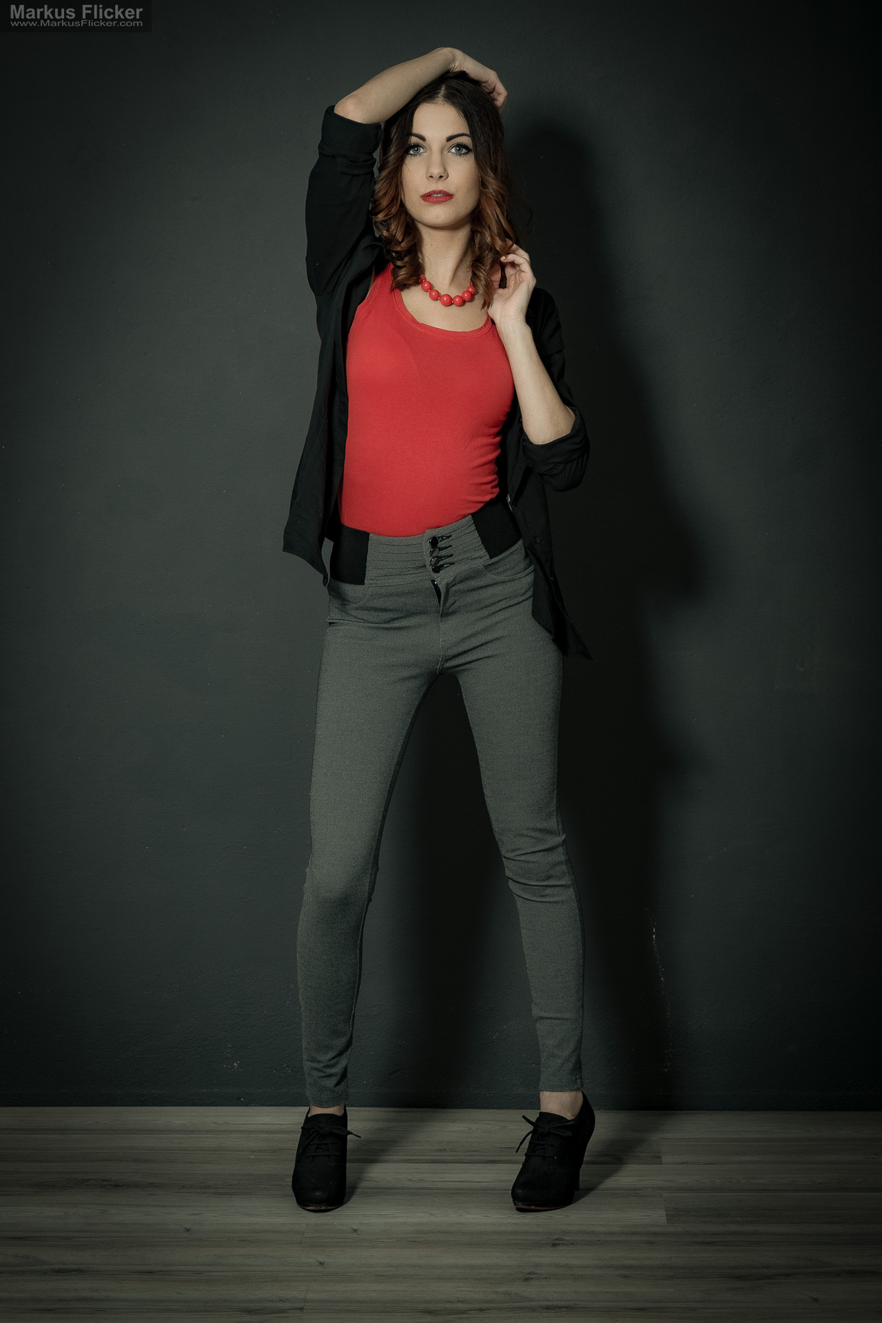 Fashion Portrait Fotografie im Studio – kreatives Model Posing mit rotem Outfit vor dunklem Hintergrund Fashion Portrait Fotografie im Studio – kreatives Model Posing mit rotem Outfit vor dunklem Hintergrund