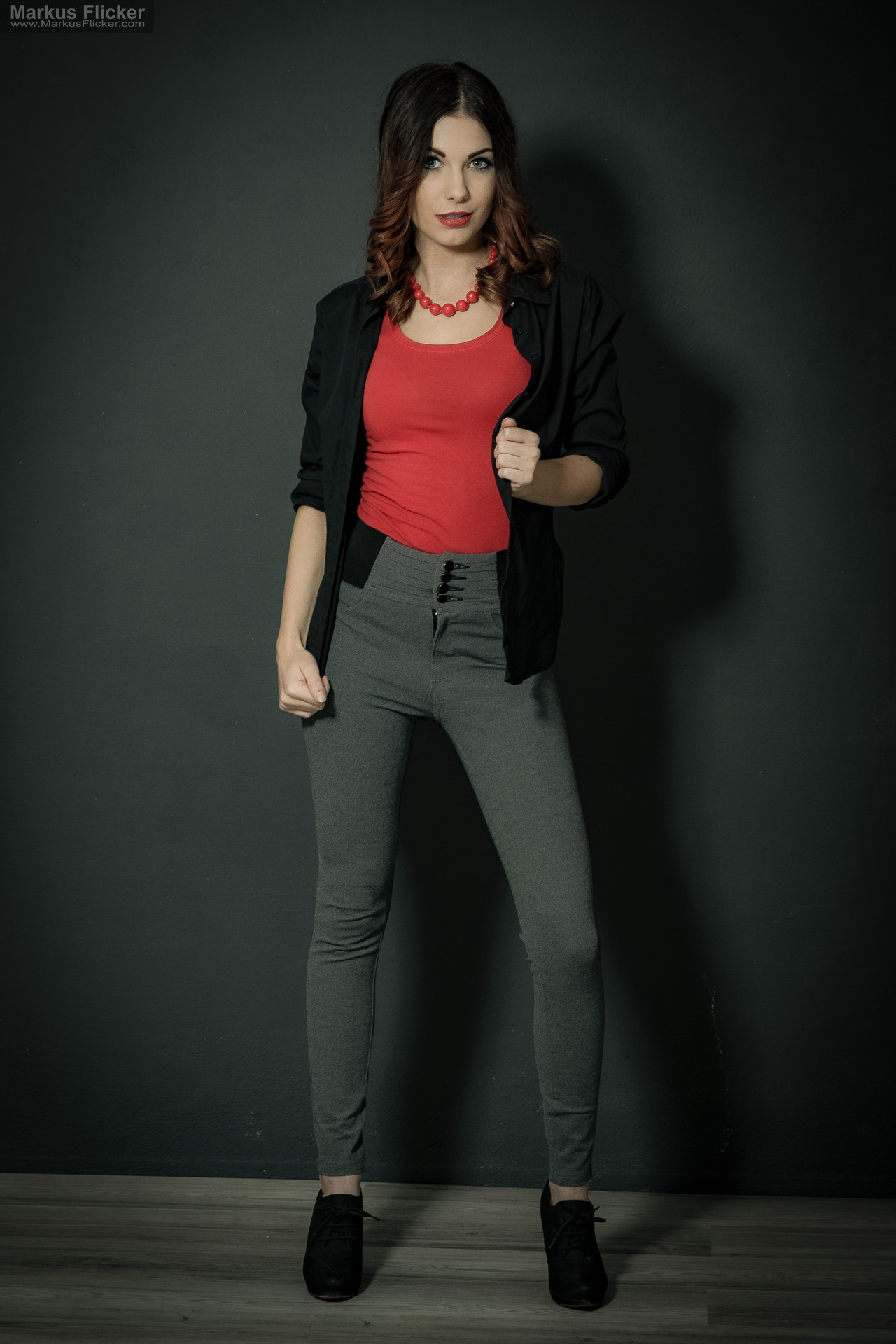 Fashion Portrait Fotografie im Studio – kreatives Model Posing mit rotem Outfit vor dunklem Hintergrund Fashion Portrait Fotografie im Studio – kreatives Model Posing mit rotem Outfit vor dunklem Hintergrund