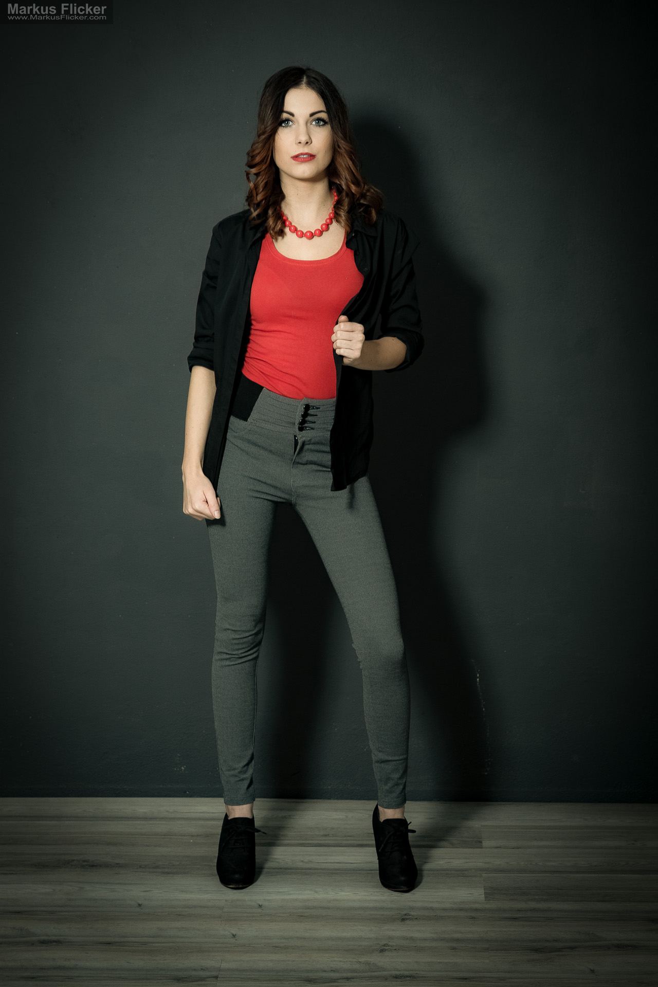 Fashion Portrait Fotografie im Studio – kreatives Model Posing mit rotem Outfit vor dunklem Hintergrund Fashion Portrait Fotografie im Studio – kreatives Model Posing mit rotem Outfit vor dunklem Hintergrund
