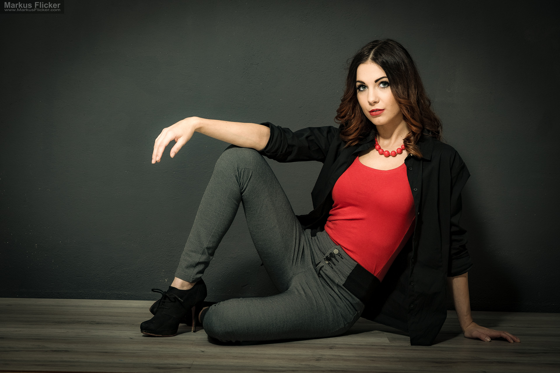Fashion Portrait Fotografie im Studio – kreatives Model Posing mit rotem Outfit vor dunklem Hintergrund Fashion Portrait Fotografie im Studio – kreatives Model Posing mit rotem Outfit vor dunklem Hintergrund