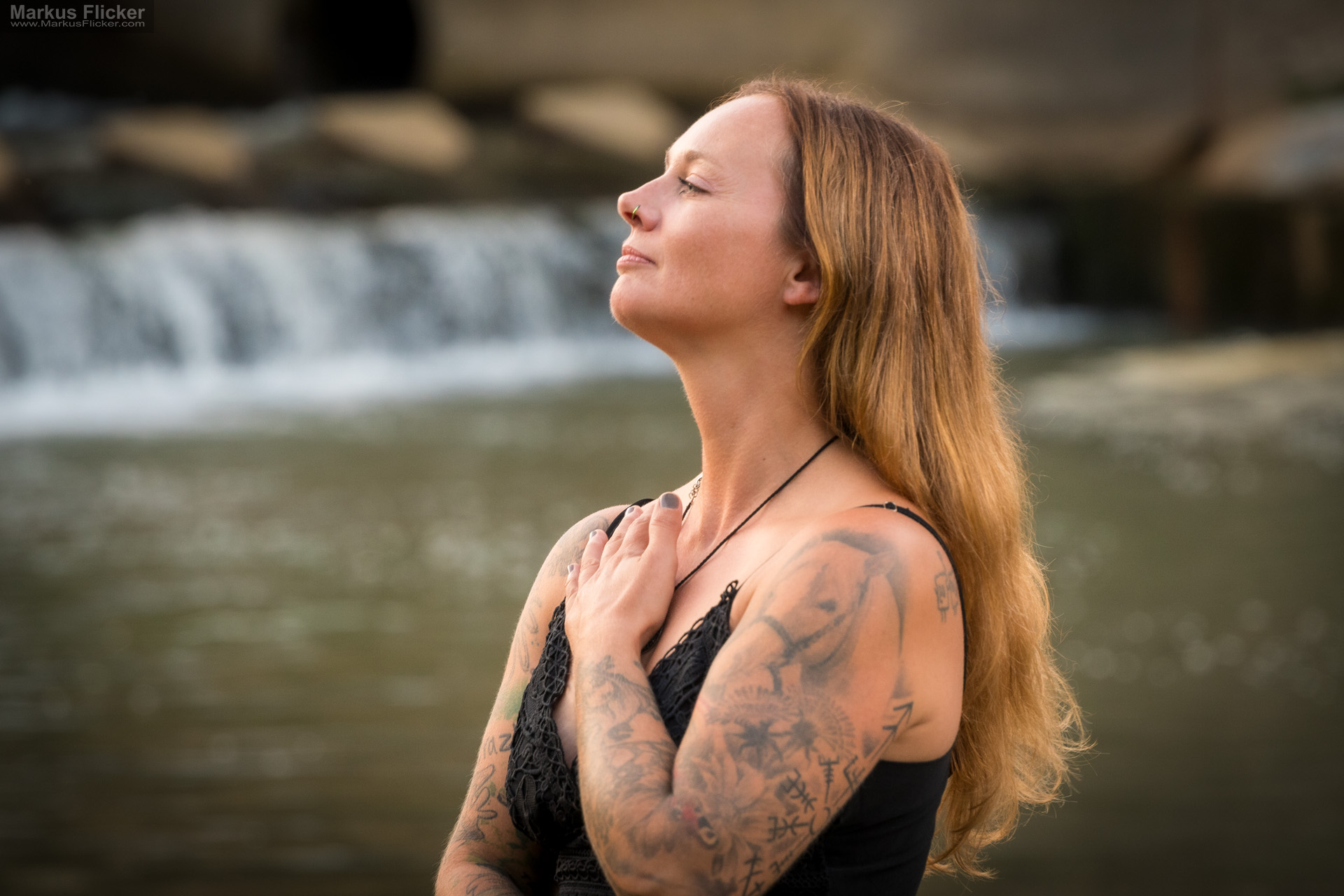 Sommerliches natürliches Portrait Model Shooting im schwarzen Kleid vor einem Wasserfall